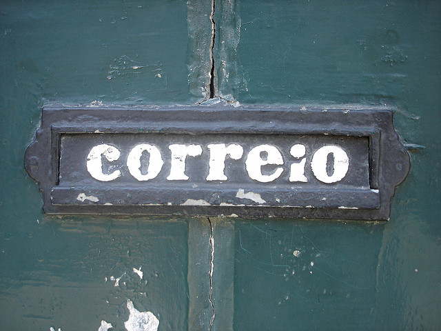 Interior de instalação dos Correios com balcão e público